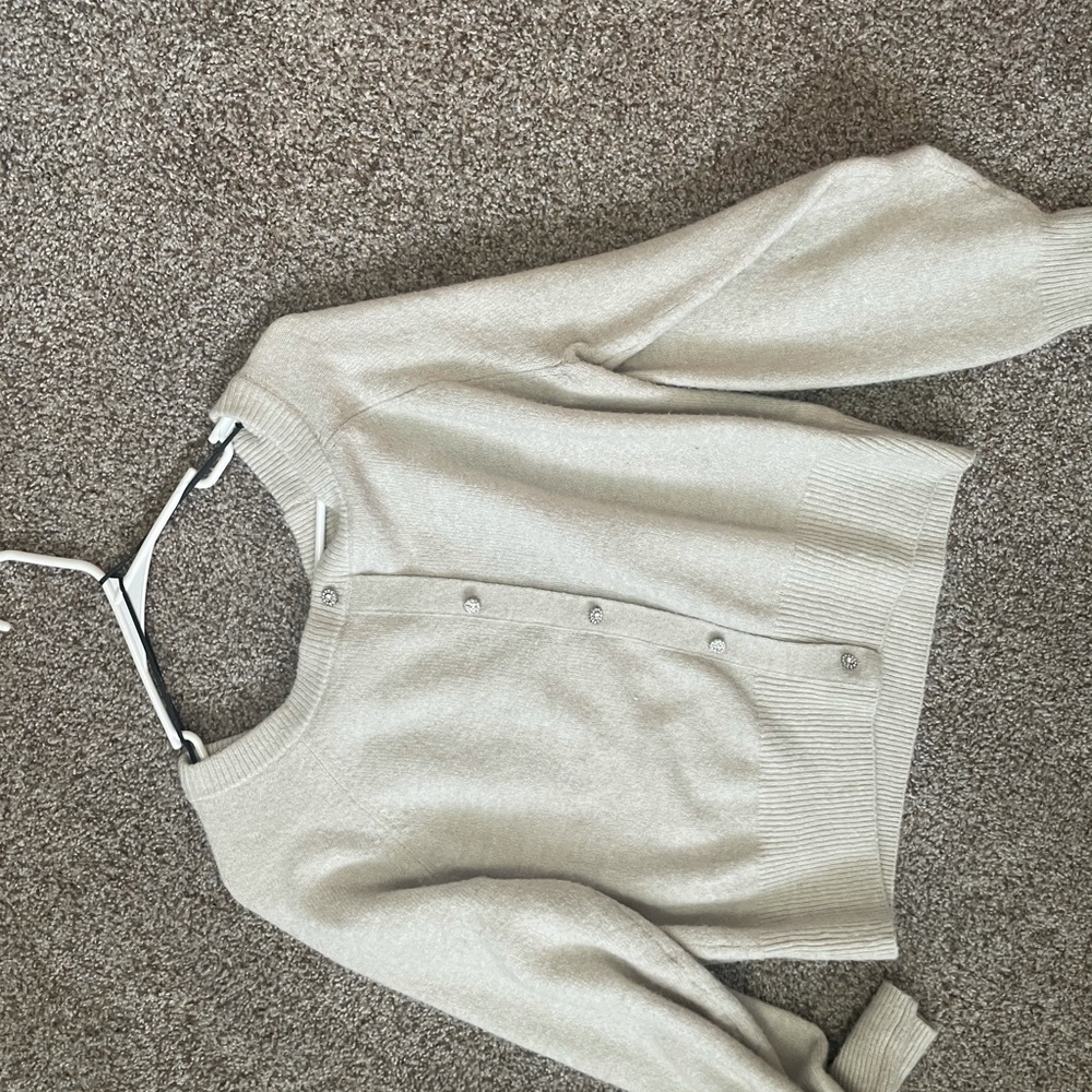Cream boat neck sweater with all the buttons attached